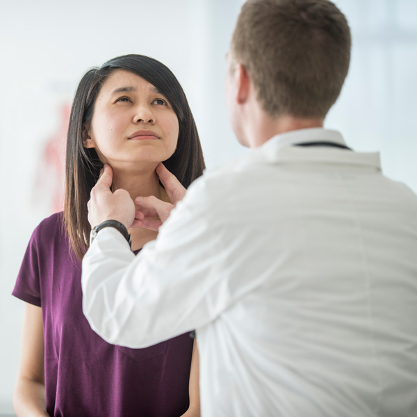 doctor examining woman's neck