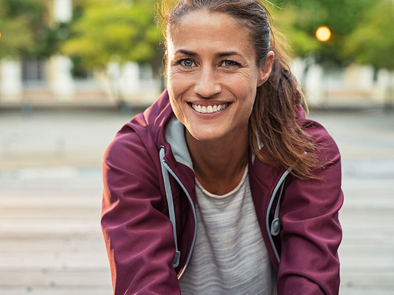 woman smiling outdoors on walk