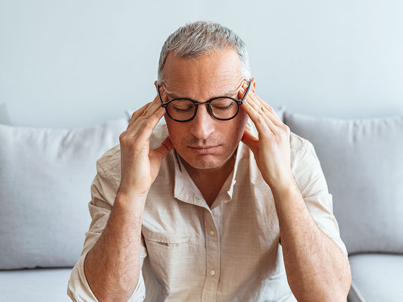 man holding sides of face in pain