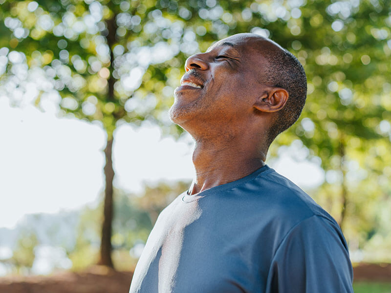 man smiling outdoors in the sunshine