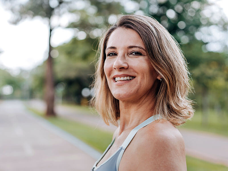 woman smiling outdoors on walk