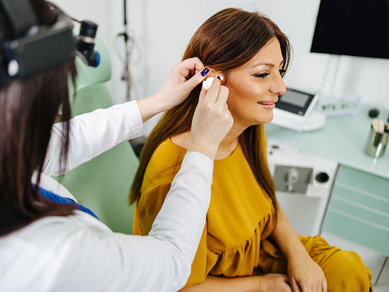 woman being examined in the ear by doctor