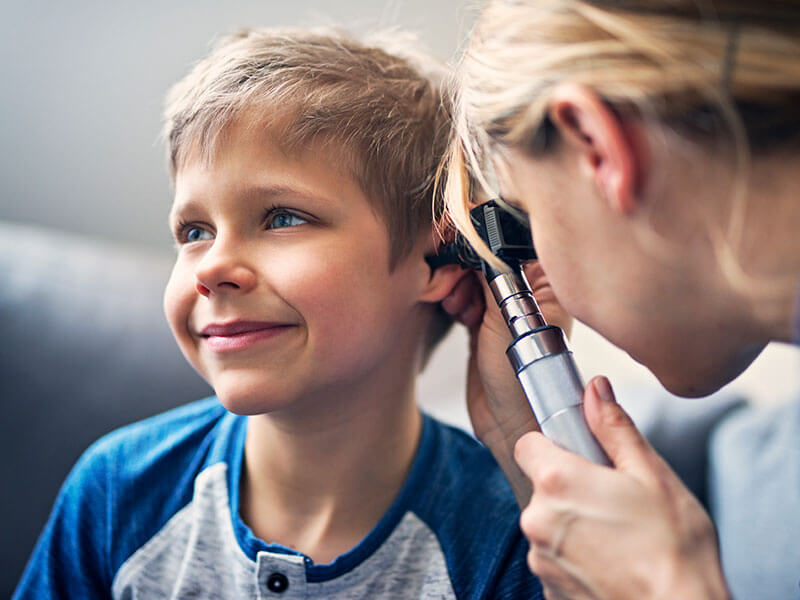 young boy being examined in the ear by doctor