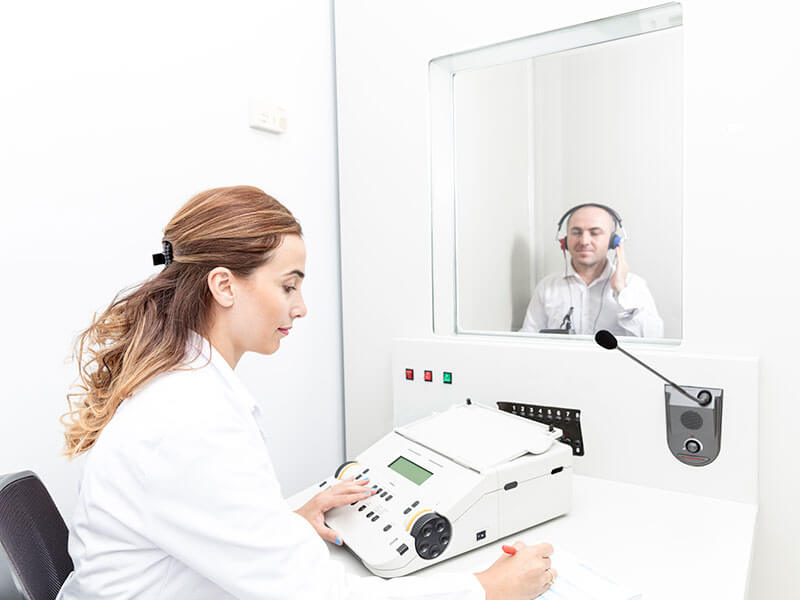 man in exam room for hearing test with doctor