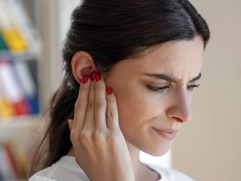 lady holding ear in pain